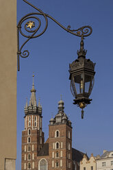 Poland, Krakow, view to St. Mary's Church with historical lantern hanging in the foreground - MELF00153