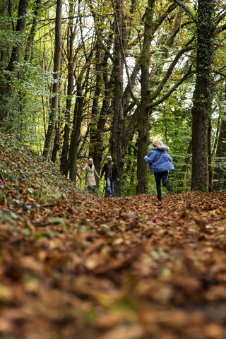 Glückliche Familie entspannt sich im herbstlichen Wald, lizenzfreies Stockfoto