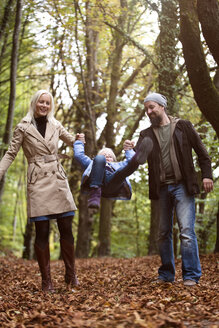 Eltern spielen mit Tochter im herbstlichen Wald - MIDF00811