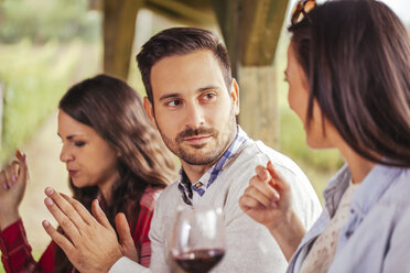 Friends socializing outdoors with red wine - ZEDF00387