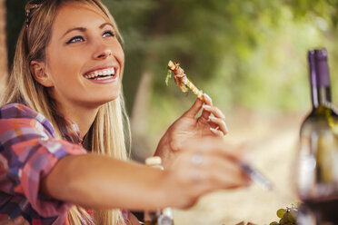 Lächelnde Frau beim Essen im Freien - ZEDF00388