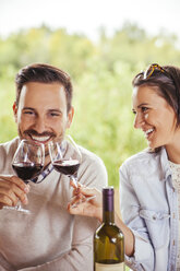 Happy couple drinking red wine outdoors - ZEDF00393