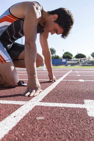 Läufer auf Tartanbahn in Startposition, lizenzfreies Stockfoto