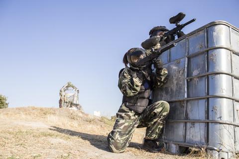 Paintball-Spieler zielen mit Paintball-Pistolen während eines Paintball-Spiels, lizenzfreies Stockfoto