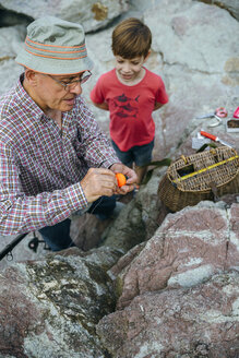 Großvater lehrt Enkel das Fischen an der Felsenküste - DAPF00420