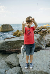 Boy holding fish on fishing line - DAPF00440