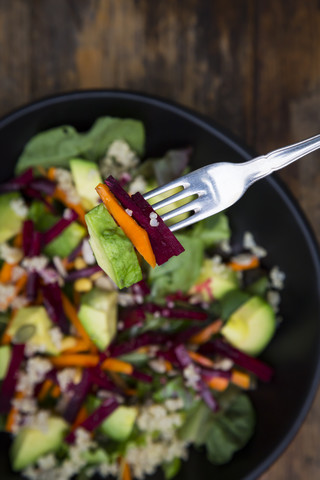 Bowl of autumnal salad with lettuce, carrots, avocado, beetroot, pumpkin and sunflower seeds, pomegranate and quinoa stock photo