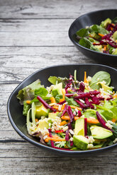 Zwei Schalen mit herbstlichem Salat mit Salat, Karotten, Avocado, Roter Bete, Samen, Granatapfel und Quinoa - LVF05496