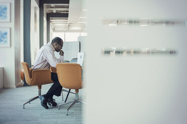 Businessman working alone in office - WESTF21811