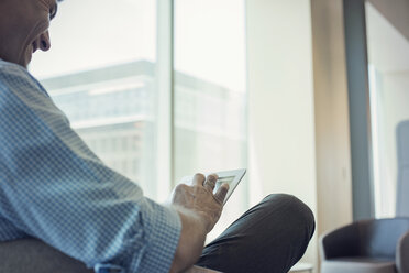 Geschäftsmann sitzt im Büro und benutzt ein digitales Tablet - WESTF21832