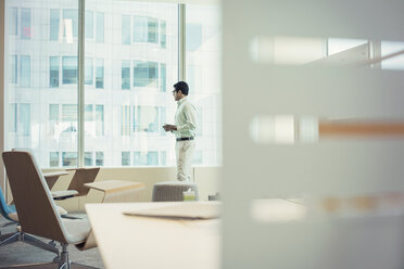 Businessman standing at window - WESTF21848