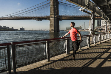 USA, New York City, sportlicher Mann beim Stretching am East River - UUF08830