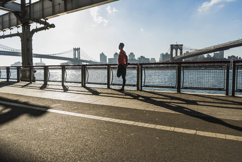 USA, New York City, sportlicher Mann beim Stretching am East River - UUF08832