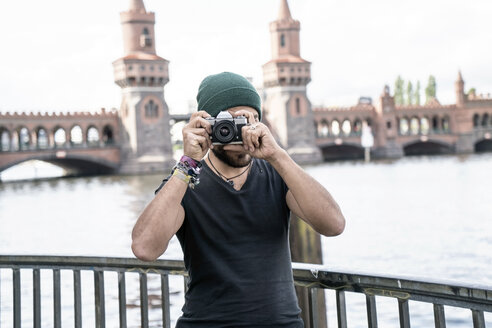 Germany, Berlin, man standing in front of Oberbaum taking pictures from viewer - TAMF00704