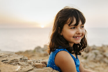 Portrait of happy little girl near the sea at sunset - MGOF02571