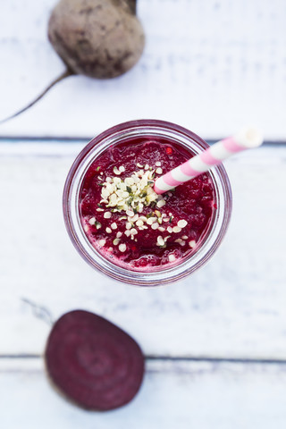 Glas Rote-Bete-Smoothie mit Hanfsamen und ganzer und in Scheiben geschnittener Roter Bete, lizenzfreies Stockfoto