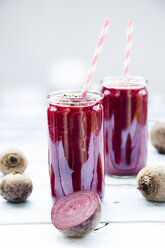 Two glasses of beetroot smoothies with hemp seed and whole and sliced beetroots - LVF05509