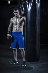 Portrait of boxer standing at punch bag - ZEF11087