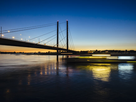 Deutschland, Düsseldorf, Blick auf die Rheinknie-Brücke mit dem Rhein im Vordergrund zur goldenen Stunde - KRPF01912