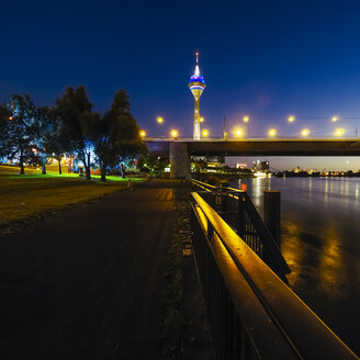 Deutschland, Düsseldorf, Blick auf beleuchtete Rheinknie-Brücke und Fernsehturm bei Nacht - KRPF01915