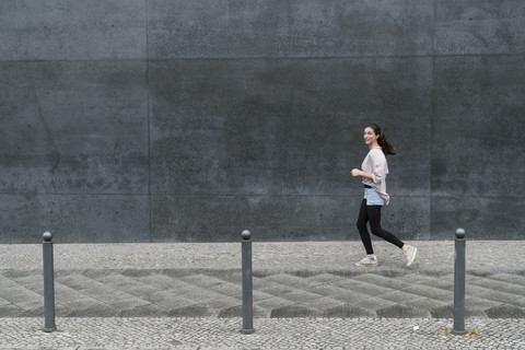 Young woman running in the city stock photo