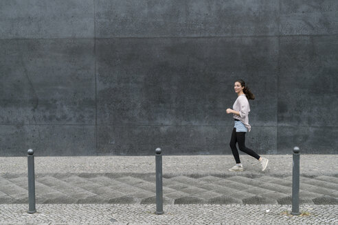 Young woman running in the city - TAMF00739