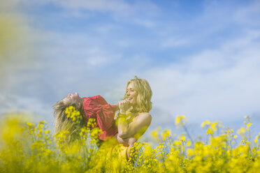 Mother and little daughter having fun together in rape field - ZEF11127