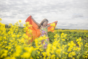 Little girl with orange cloth standing in rape field - ZEF11135