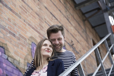 Smiling couple on stairs outdoors - SUF00112