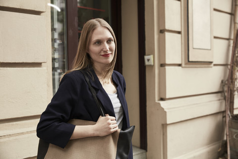Lächelnde Frau mit Tasche im Freien, lizenzfreies Stockfoto