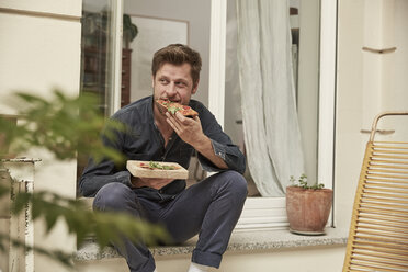 Mann isst Pizza auf der Türschwelle - SUF00131
