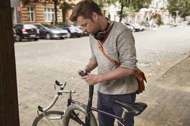 Mann schließt Fahrrad in der Stadt ab - SUF00141