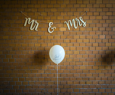 Wanddekoration bei einer Hochzeit, Luftballon gegen Backsteinmauer - MPAF00065
