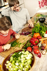 Boy and girl chopping vegetables in the kitchen - TSFF00130