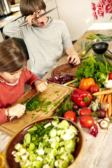 Junge und Mädchen hacken Gemüse in der Küche - TSFF00130