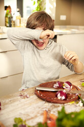 Boy chopping onions covering his eyes - TSFF00134