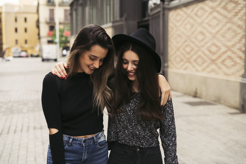 Two happy best friends arm in arm in autumn stock photo