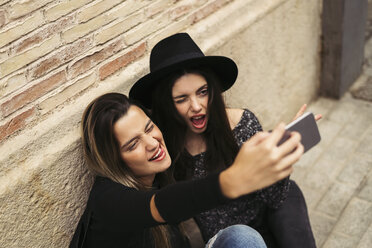 Zwei beste Freunde ziehen lustige Gesichter bei der Aufnahme von Selfie mit Handy - EBSF01860