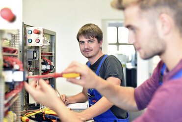 Two electrician students working at electrical panel - LYF00611