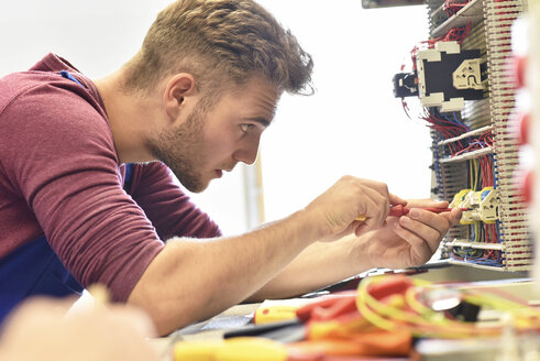 Electrician student working at electrical panel - LYF00615