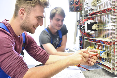 Two electrician students working at electrical panel - LYF00617