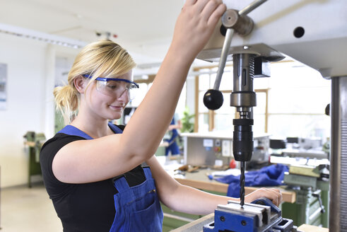 Female trainee working at press drill - LYF00629