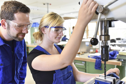 Instructor with female trainee at drill machine stock photo