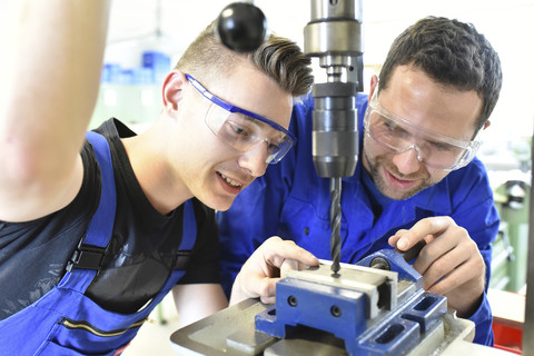 Instructor with trainee at drill machine stock photo