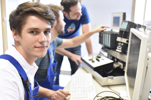 Portrait of smiling student with technical instructor in background - LYF00634