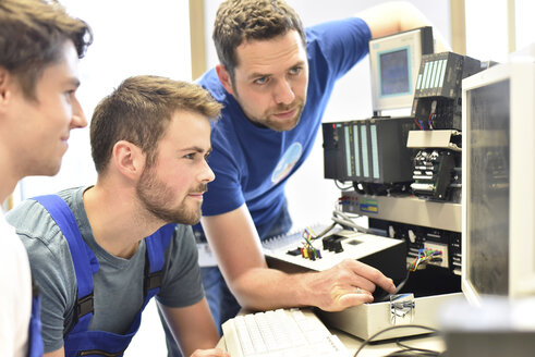 Technical instructor teaching students at computer screen - LYF00638