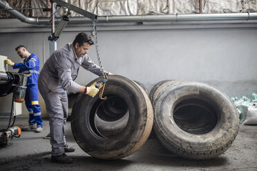 Tire repairer checking tire in factory - ZEF11145