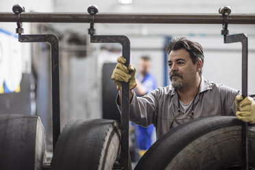 Tire repairer adjusting hooks on tires - ZEF11163