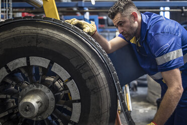 Reifenreparateur beim Auftragen der Lauffläche eines Reifens - ZEF11178