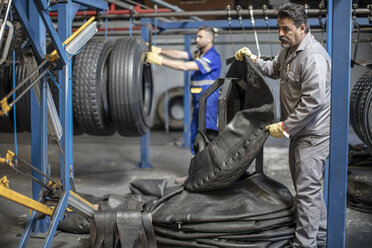 Zwei Reifenreparateure arbeiten in einer Fabrik - ZEF11179